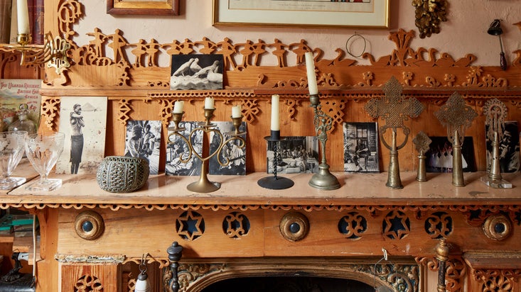 Candles and picture postcards on a mantlepiece with decorative fretwork at 575 Wandsworth Road, London